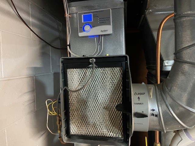 AprilAire whole home humidifier with the cover removed exposing the filter - Binder