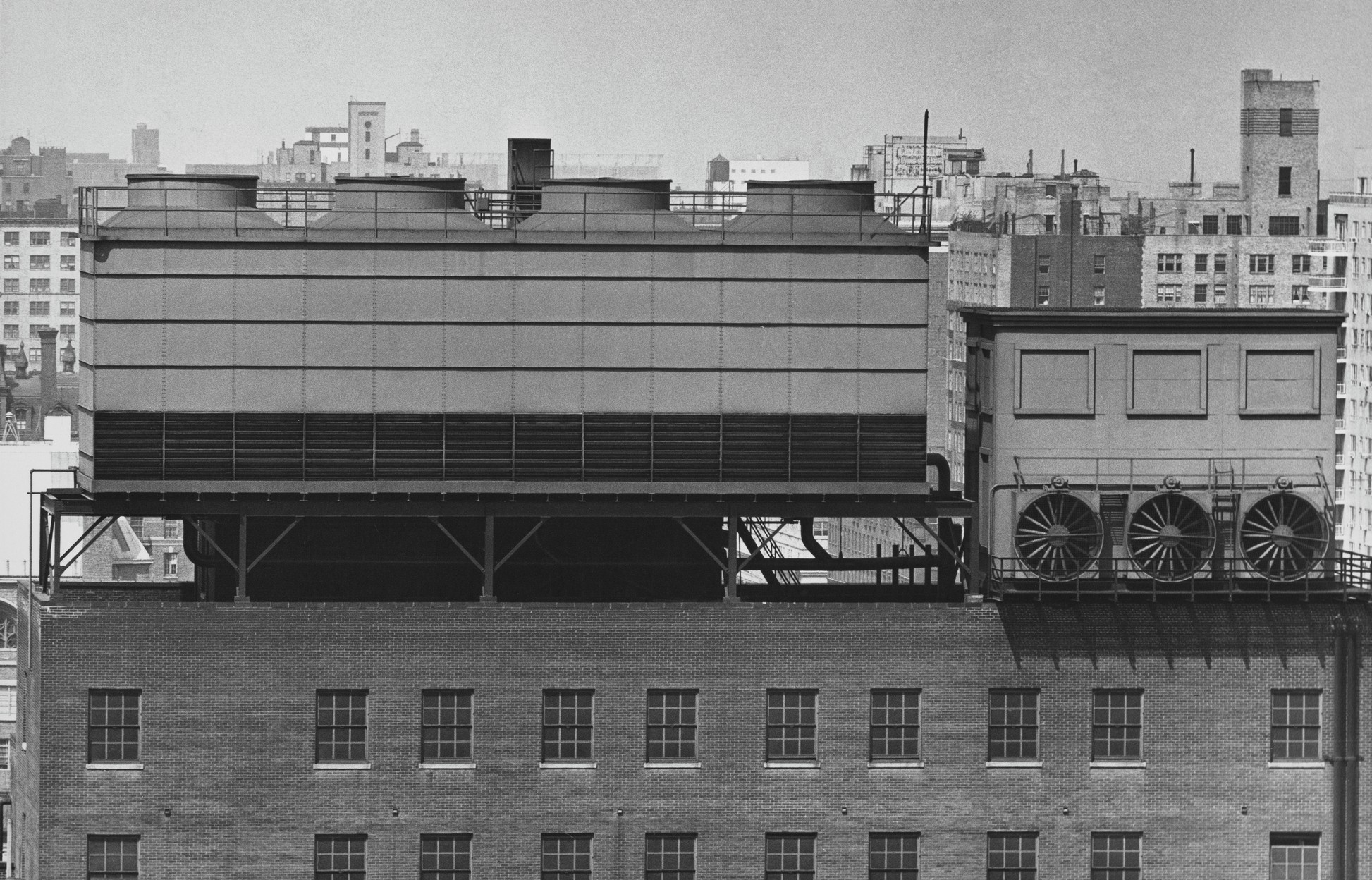 Cooling towers mounted on a rooftop alongside early air-conditioning units, circa 1955.